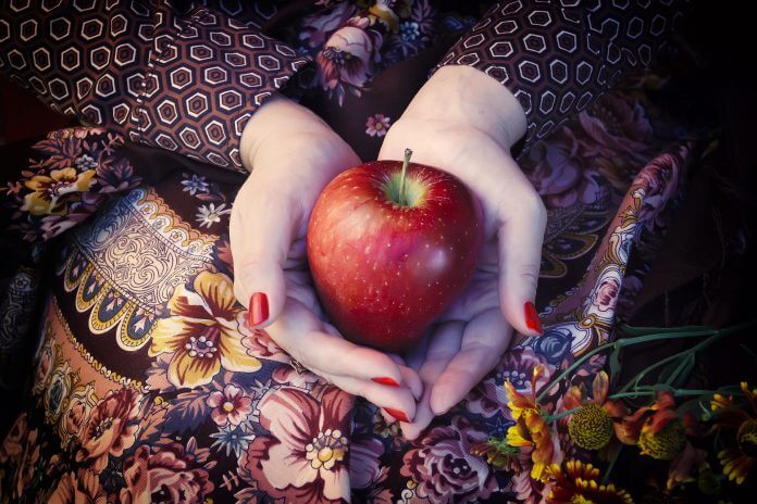 Frutarier hält Apfel in den Händen.