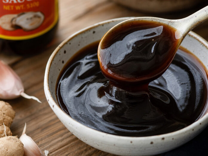 Austernsauce Schale Nahaufnahme Eine Schale dunkle, glänzende Austernsauce mit Löffel in Nahaufnahme