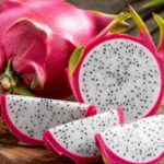 Aufgeschnittene Drachenfrucht mit weißem Fruchtfleisch und schwarzen Kernen