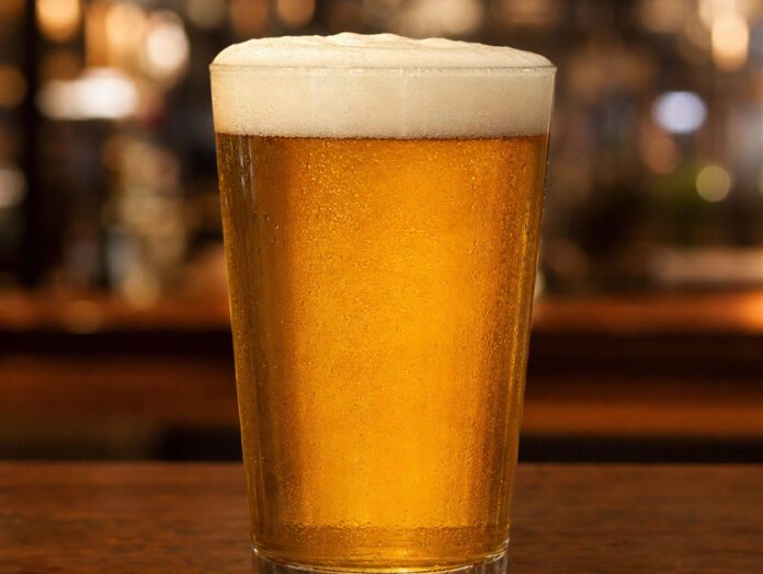 Ein neutrales Glas goldenes Bier mit Schaumkrone