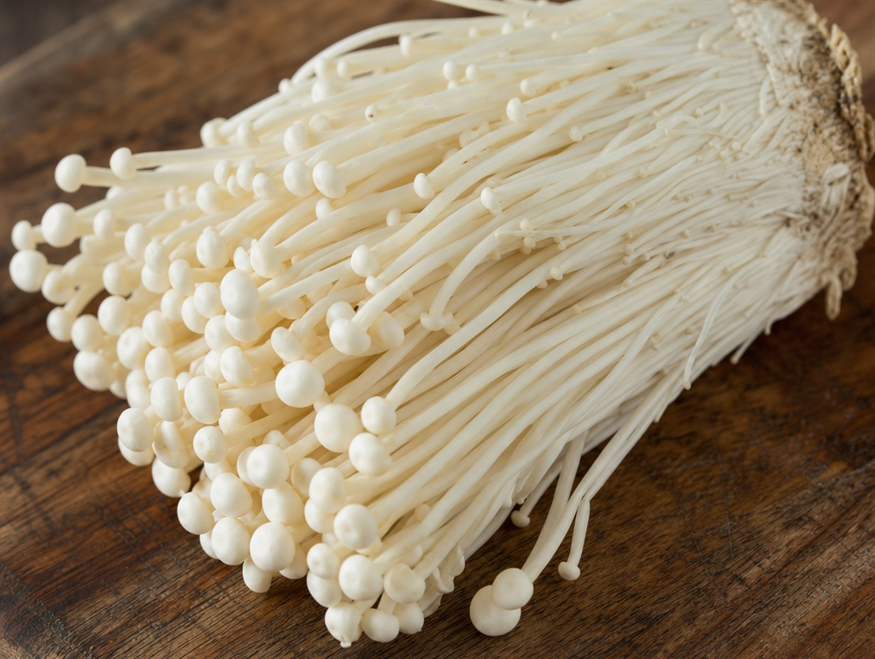 Frisches Bündel Enoki-Pilze mit langen dünnen weißen Stielen