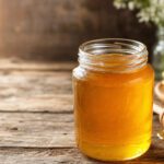 Glas mit goldenem Honig auf Holztisch