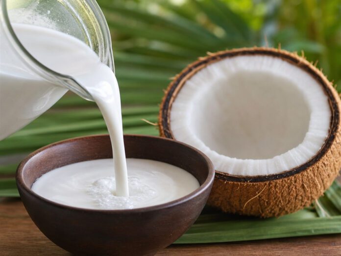Kokosmilch neben aufgeschnittener Kokosnuss