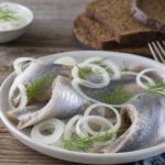 Matjeshering mit Zwiebelringen auf einem Teller