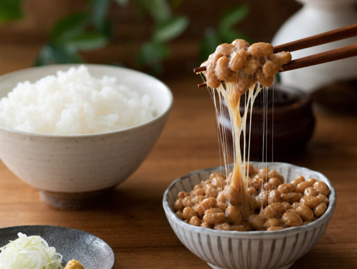 Natto Schale Fäden Stäbchen Eine Schale Natto mit klebrigen Fäden, angehoben mit Stäbchen