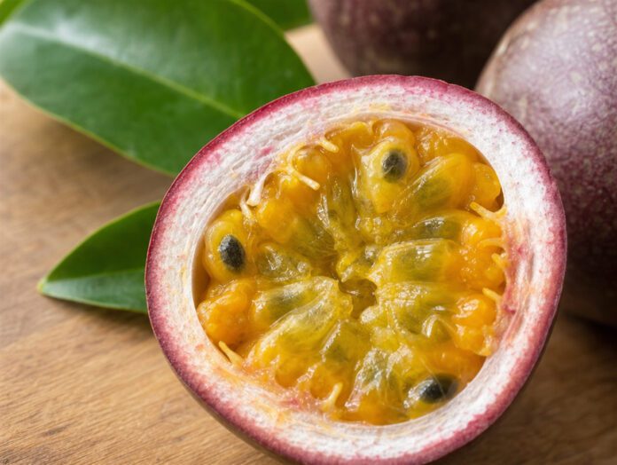 Halbierte Passionsfrucht mit gelb-orangem, gallertartigem Fruchtfleisch und schwarzen Kernen