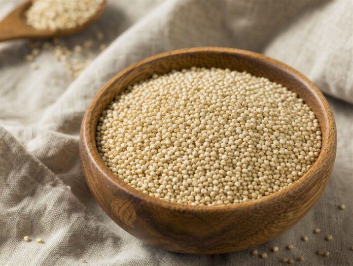 Rohe Quinoa-Körner Rohe Quinoa-Körner in einer Holzschale auf Leinenstoff