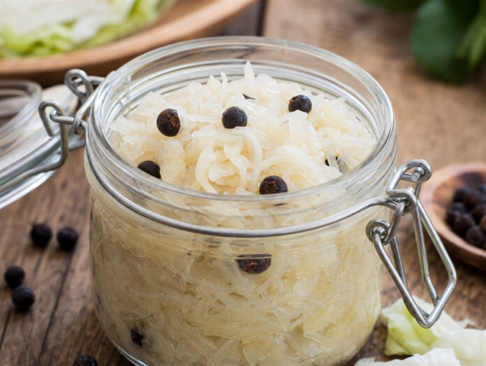 Sauerkraut im Glas Frisches Sauerkraut mit Wacholderbeeren in einem Glas