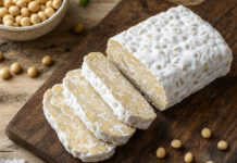 Wie schmeckt Tempeh? Angeschnittener Tempeh-Block zeigt die festen Sojabohnen und das weiße Myzel