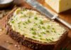 Tag des Deutschen Butterbrotes: Termin, Butterarten und Zahlen Dicke Scheibe dunkles Roggenbrot mit kalter Butter bestrichen, mit grobem Salz und Schnittlauch bestreut