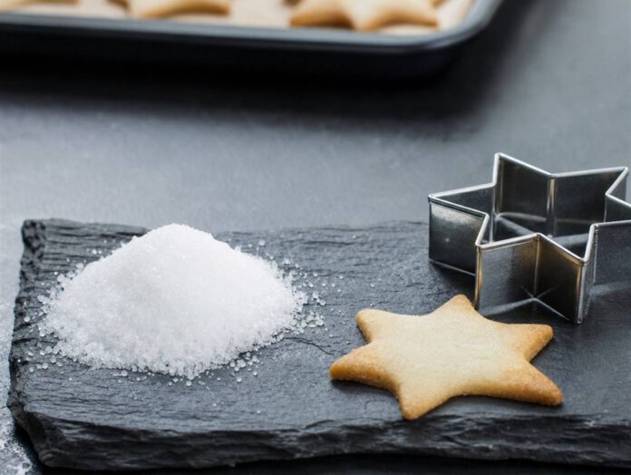 Häufchen weißes kristallines Hirschhornsalz auf einer Schieferplatte, daneben ein flaches Sternplätzchen und ein Ausstecher