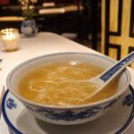 Klare Suppe mit zarten durchscheinenden Fäden in einer chinesischen Porzellanschale