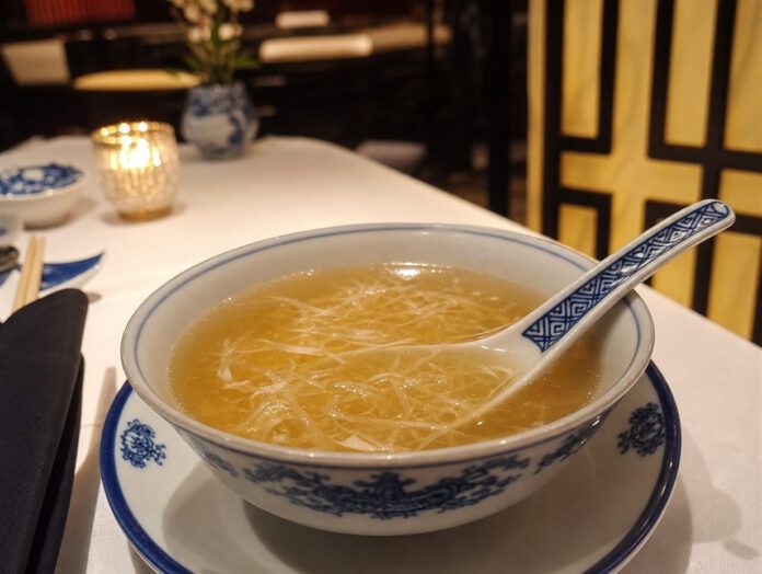 Klare Suppe mit zarten durchscheinenden Fäden in einer chinesischen Porzellanschale