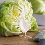 Aufgeschnittener Kopfsalat, an dessen Strunk weißer Milchsaft austritt