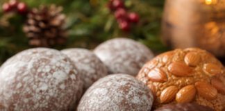 Was ist Lebkuchen? Mehrere runde Oblatenlebkuchen mit Zuckerglasur, Schokoladenüberzug und Mandelbelag, einer angebrochen mit sichtbarer nussiger Masse