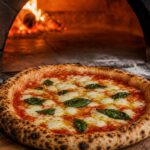 Neapolitanische Margherita auf einem Holzschieber mit luftigem Rand und dunklen Blasen vor der Öffnung eines Holzofens