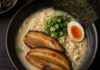 Wie schmeckt Ramen? Schale Ramen von oben mit trüber heller Brühe, gewellten Nudeln, Schweinebauchscheiben, halbem Ei, Frühlingszwiebeln und Nori