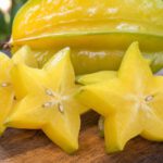 Aufgeschnittene Sternfrucht (Karambole) auf einem Holzbrett
