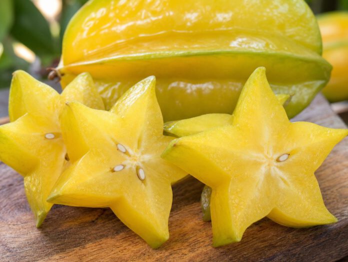 Aufgeschnittene Sternfrucht (Karambole) auf einem Holzbrett