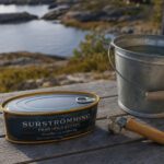 Gewölbte Konservendose mit fermentiertem Hering auf einem Holztisch am Wasser
