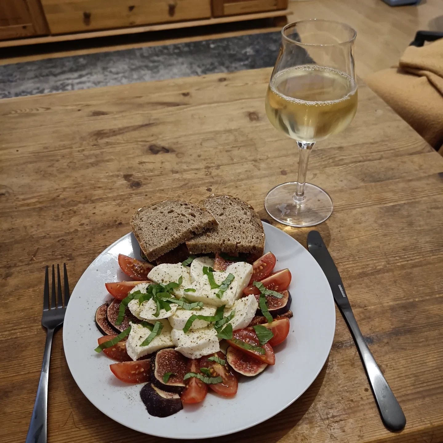 Mozzarella mit frischen Feigen, Tomaten und Basilikum auf einem Teller