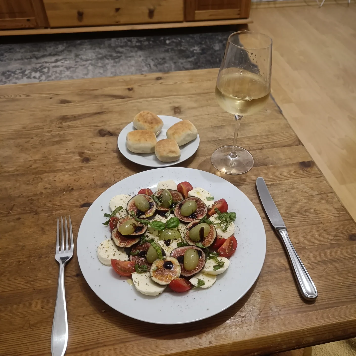 Mozzarellascheiben mit Feigen, grünen Trauben und Balsamico