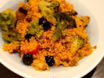 Couscous mit Brokkoli, schwarzen Oliven, Aubergine und Tomate in einer Schale