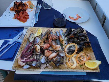Gemischte Meeresfrüchteplatte mit Miesmuscheln, Venusmuscheln, Garnelen und Calamari-Ringen, dazu Zitrone