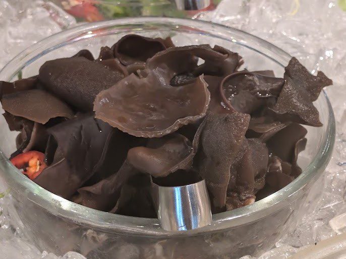Eingeweichte Mu-Err-Pilze, auch Judasohren genannt, in einer Glasschale auf Eis