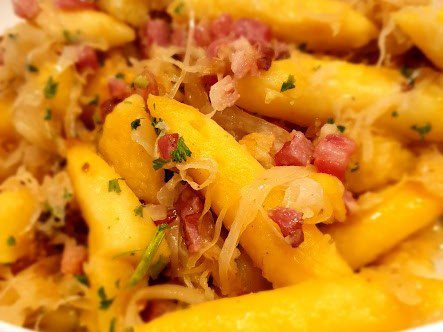 Schupfnudeln mit Sauerkraut, Speckwürfeln und Petersilie in einer Schale