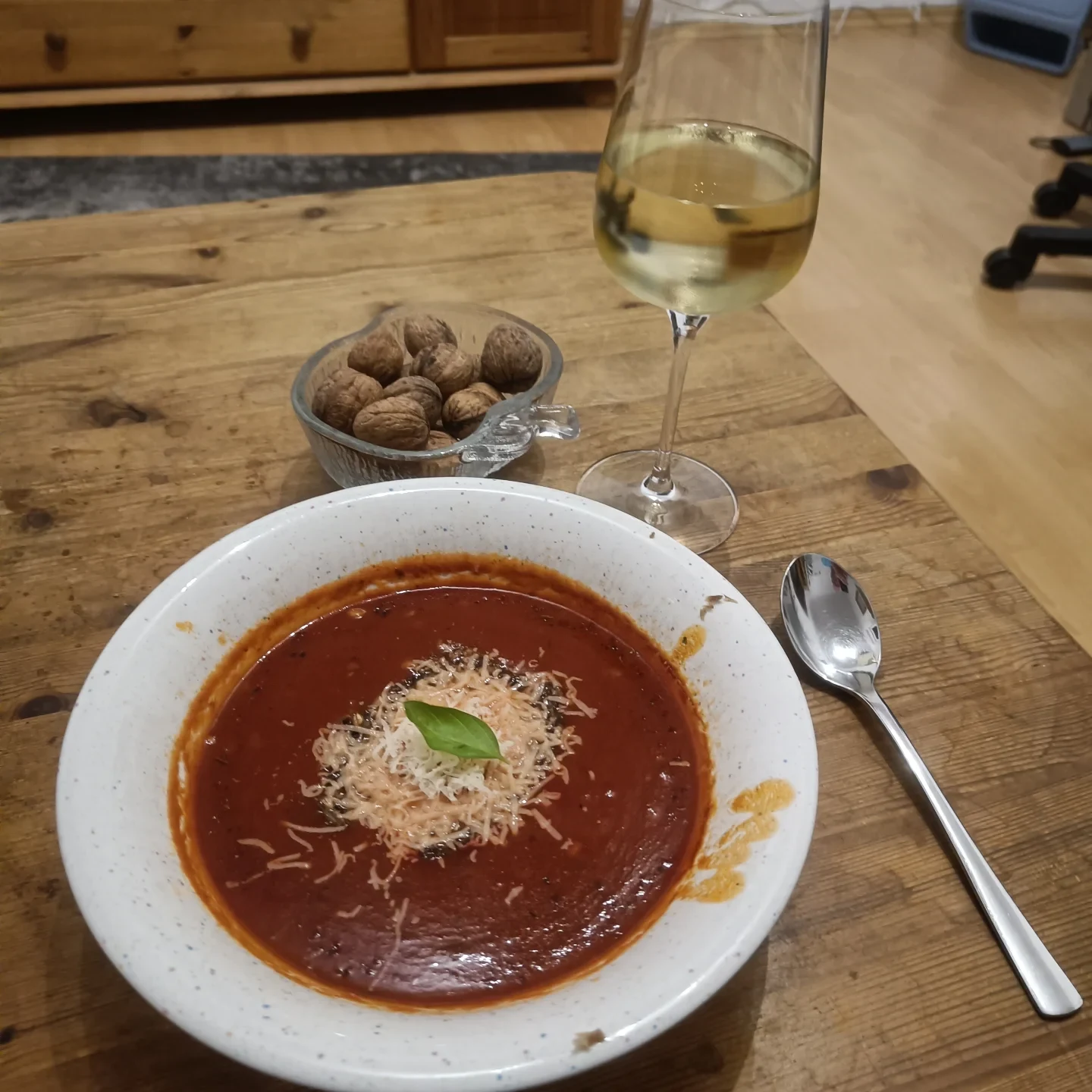 Tomatensuppe mit geriebenem Parmesan und einem Basilikumblatt