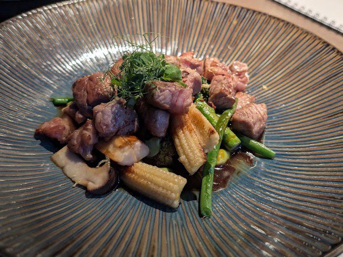 Wokgericht mit Rindfleischwürfeln, Babymais, grünen Bohnen und Shiitake in dunkler Sauce