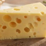 Emmentaler mit großen Löchern auf einem Holzbrett