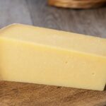 Stück Gruyère auf einem Holzbrett