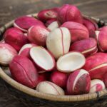 Rote und weiße Kolanüsse in einer geflochtenen Schale