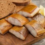 Räucheraal auf einem Holzbrett mit Zitrone