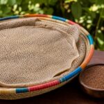 Injera aus Teff auf einem geflochtenen Korb, daneben Teffkörner